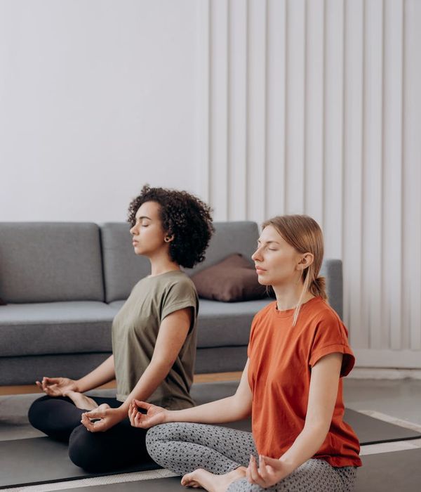 Woman in a graceful yoga pose in a bright, minimalist room.